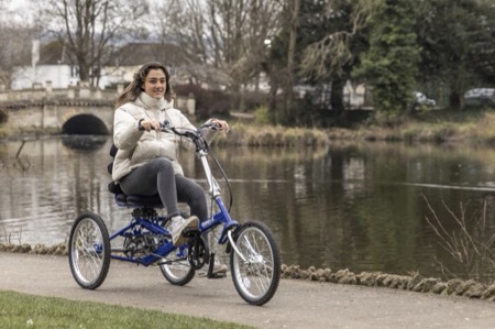 Vrouw met een hernia aan het fietsen op een driewieler voor volwassenen