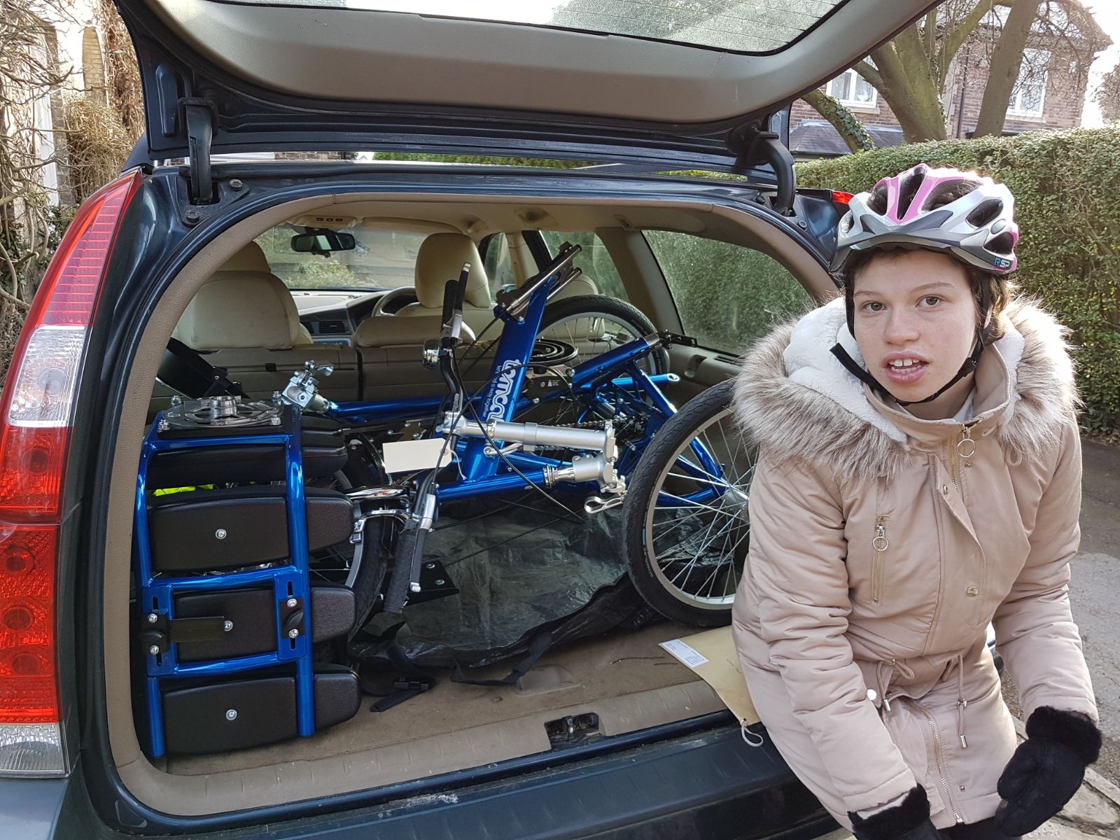 Opgevouwen Tomcat Trike in de achterbak van een auto.